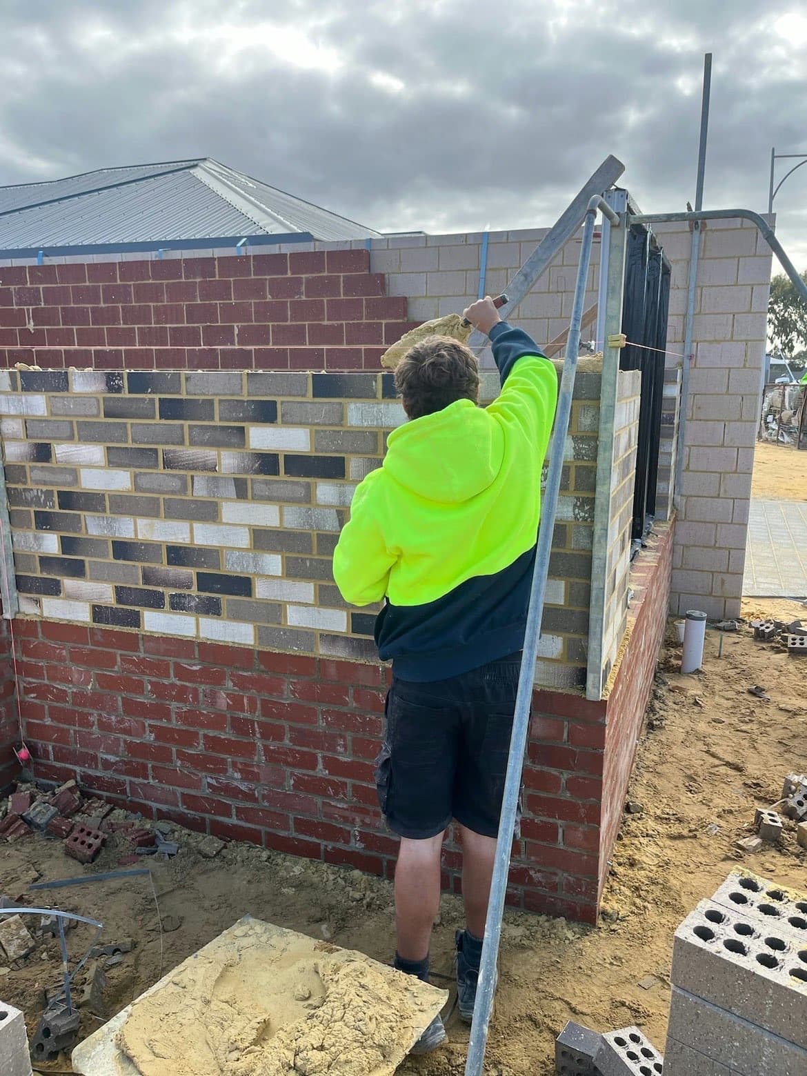 Bricklayer in high-vis laying brickwork on site — WM Bricklaying, Perth WA